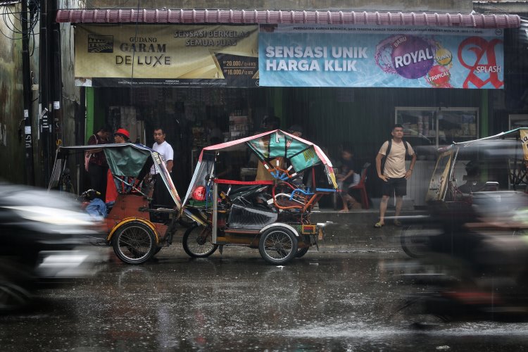 Sejumlah tukang becak berteduh sambil menunggu penumpang datang di Medan