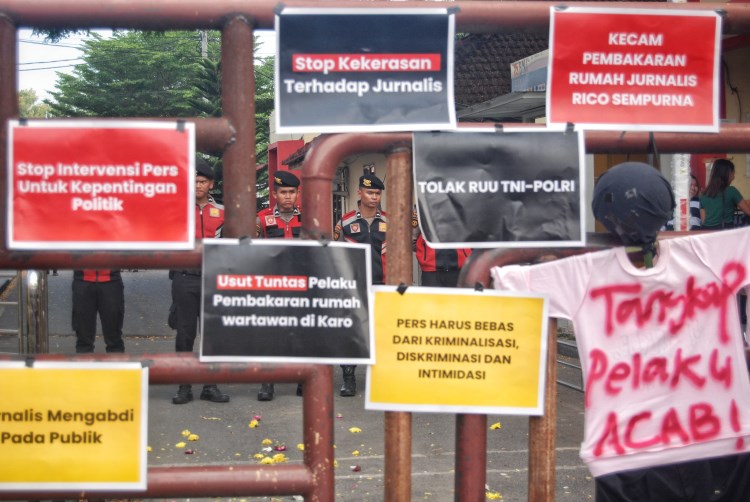 Petugas kepolisian melakukan pengamanan aksi unjuk rasa di depan Kantor Kepolisian Daerah Sumatera Utara