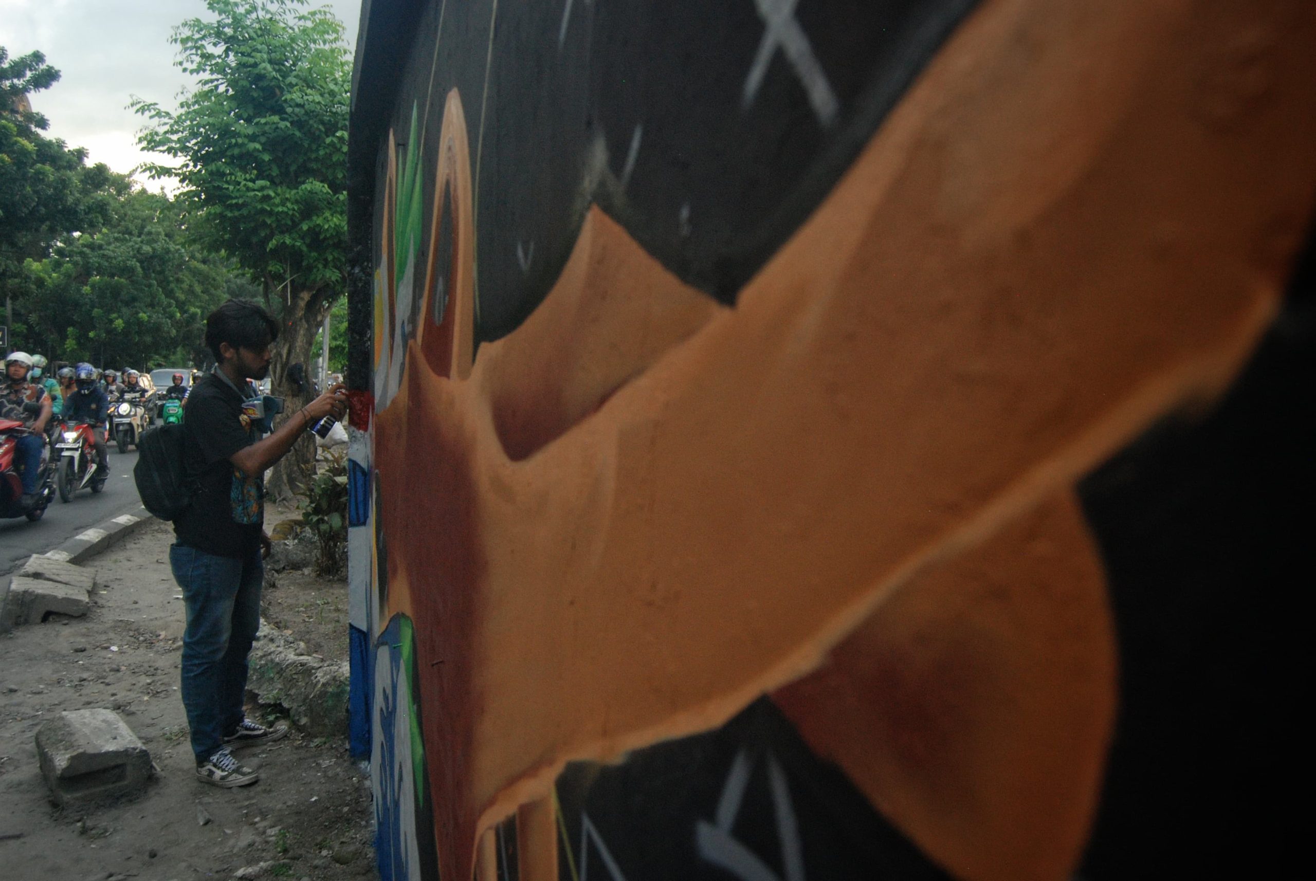 Seorang seniman menyelesaikan pembuatan lukisan mural di sepanjang Jalan Adam Malik, Medan, Sumatera Utara