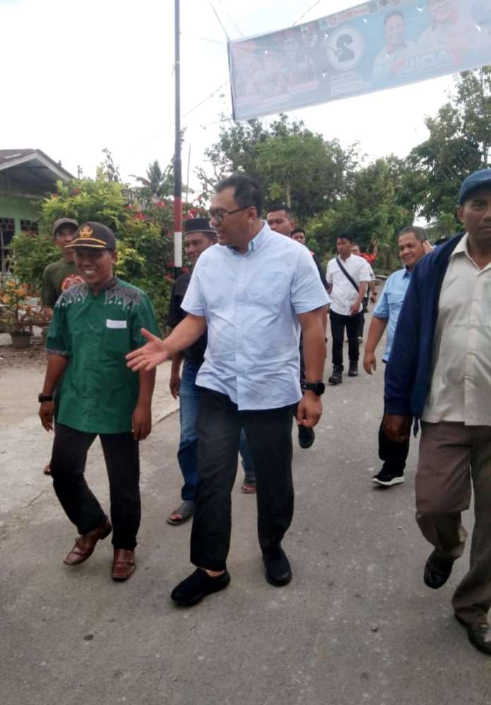 Calon Bupati Deli Serdang nomor urut 2, dr. Asri Ludin Tambunan bersama warga disela pengecoran bahu Jalan Amri Tambunan di Dusun 7A, Desa Sei Mencirim, Kecamatan Sunggal, Kamis (7/11/24) sore. 